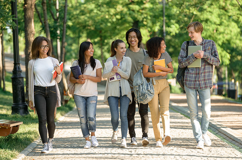 International Students Image of multiethnic group of happy young students walking outdoors.