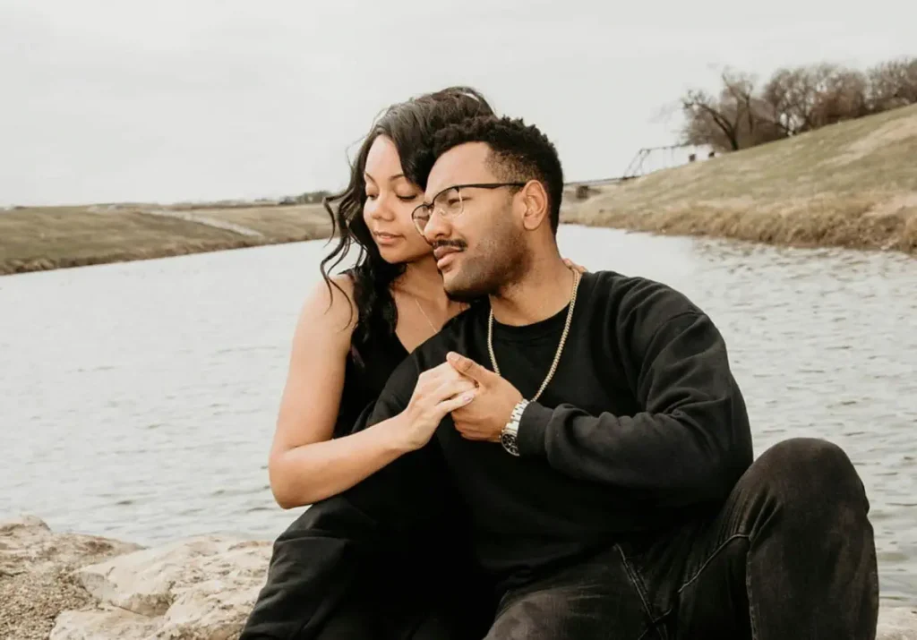 Couple sitting by the water with holding hands