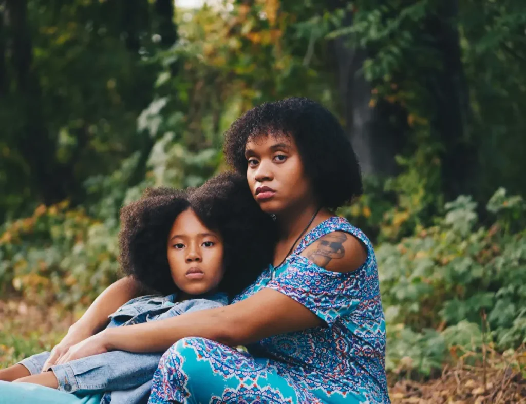 Mother and daughter sitting together in a forest